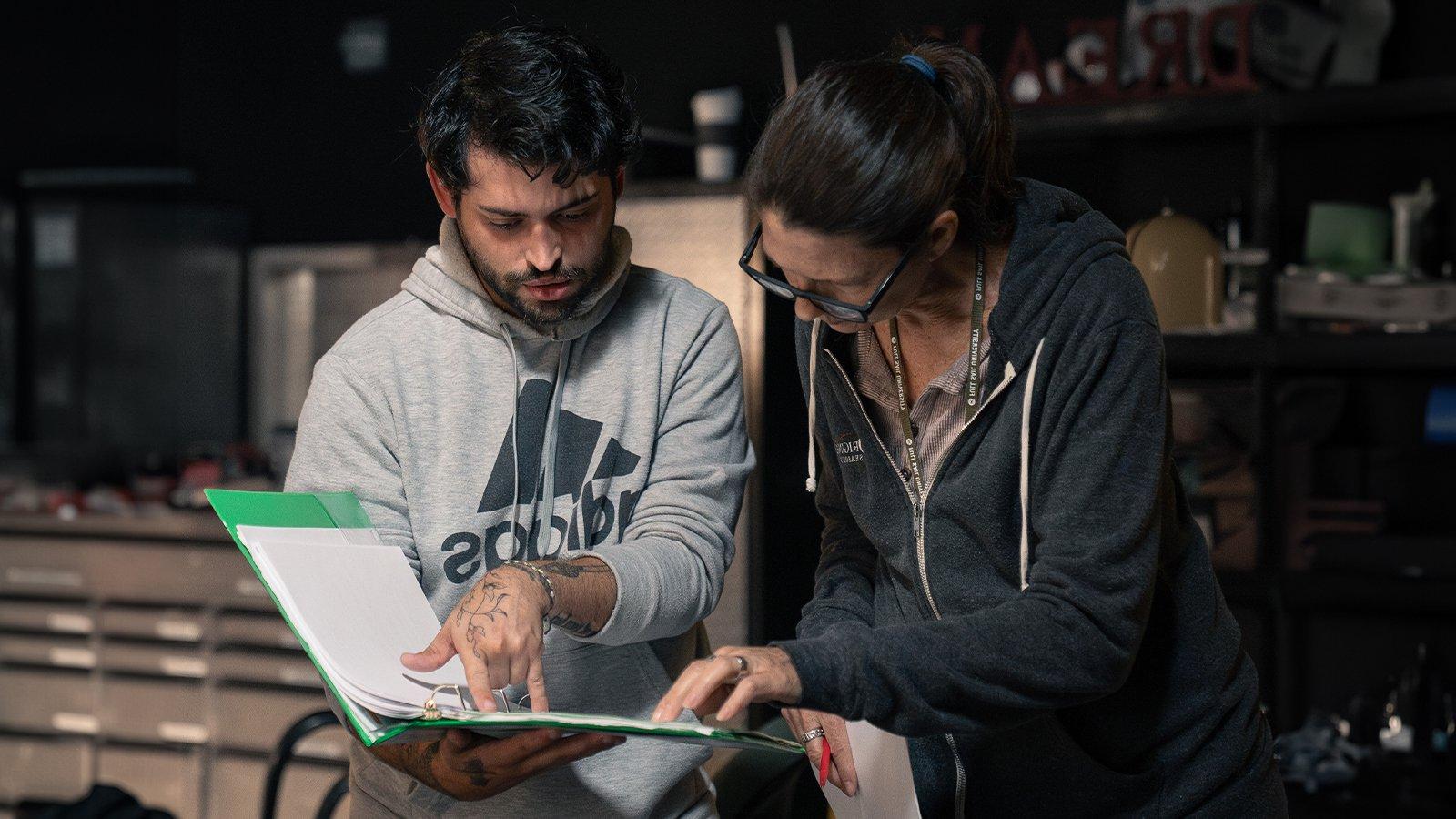 Deborah Walters helps student script supervisor Ryan Bessette with script on set