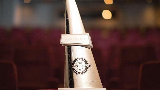 A gold, triangular statuette with the words Hall of Fame overlaid on the Full Sail University logo.