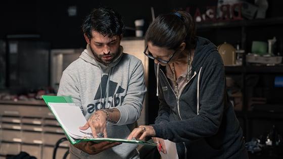 Deborah Walters helps student script supervisor Ryan Bessette with script on set