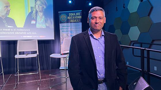 Rajiv Menon, founder of the Orlando Innovation League, 在全帆树屋的舞台前摆姿势.