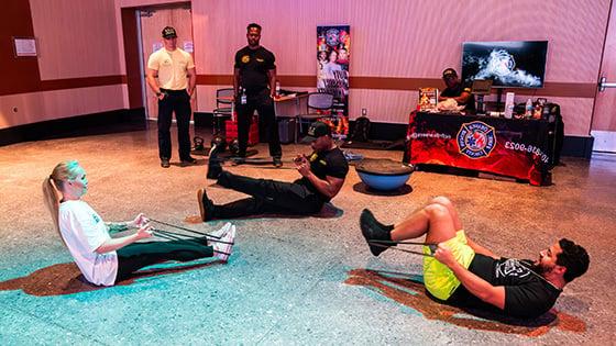 Two staff members take part in a bootcamp style workout instructed by a member of the Orange County Fire Rescue.